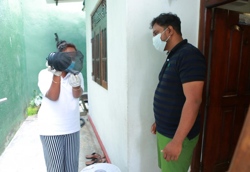 Un membre du personnel de WMP explique à Kasun Chameera le fonctionnement d'un piège à moustiques.