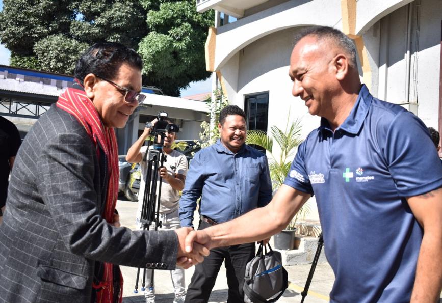 Le ministre de la Santé du Timor-Leste rencontre un bénévole d'World Mosquito Program . Caméra à l'arrière-plan. 