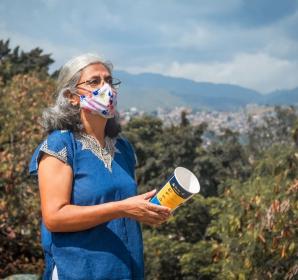 Un membre de la communauté de Cali, en Colombie, tient un Récipient pour le lâcher de moustiques